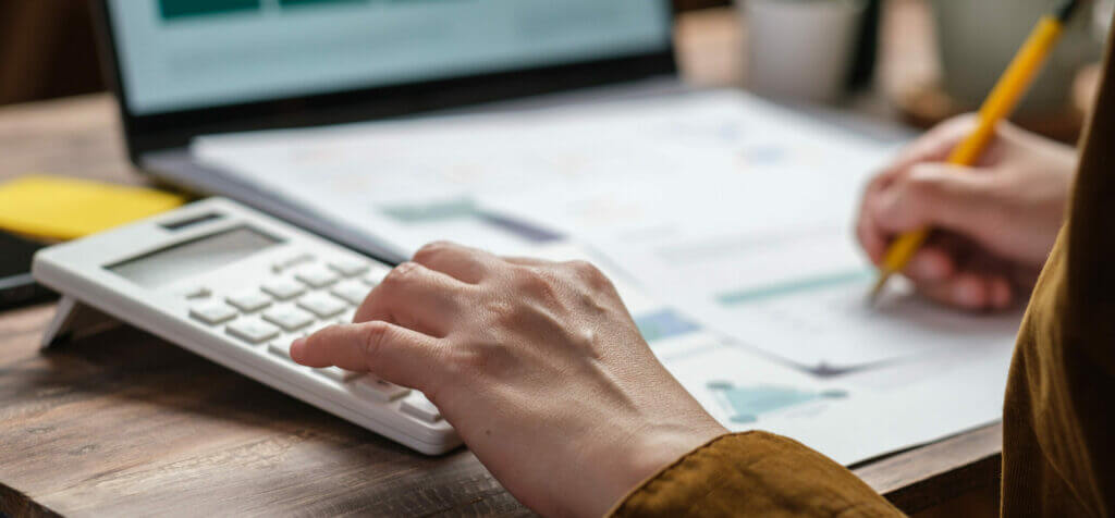 Hand using a calculator to work out taxes