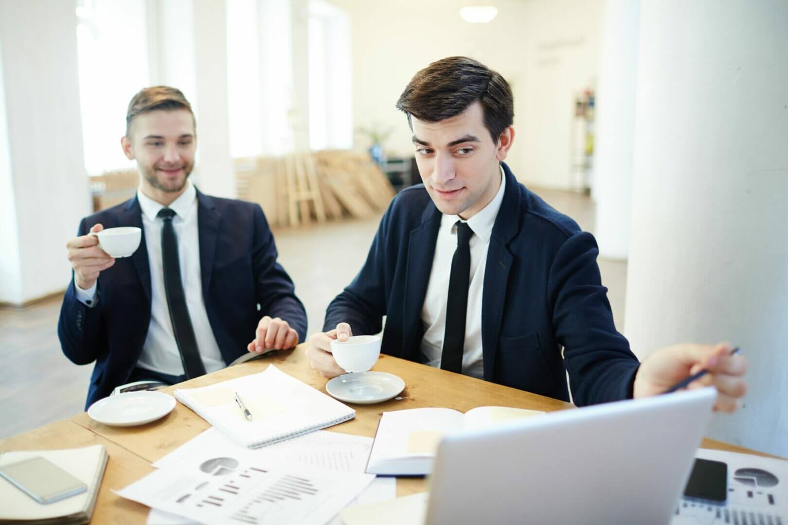 Two businessmen discussing financial information